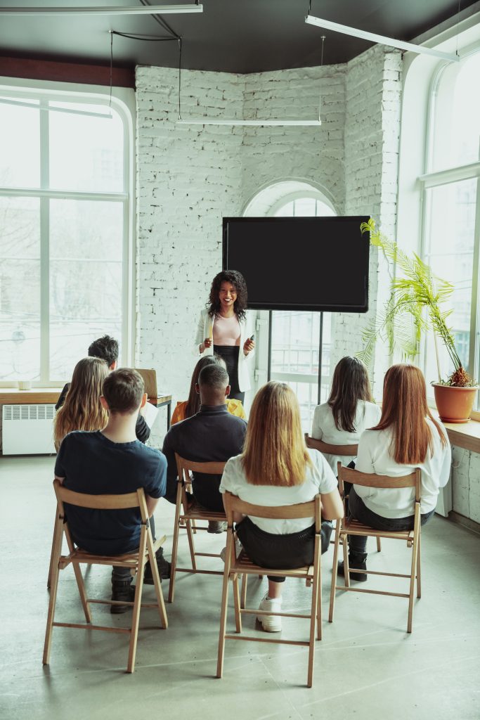 female african american speaker giving presentation hall university workshop